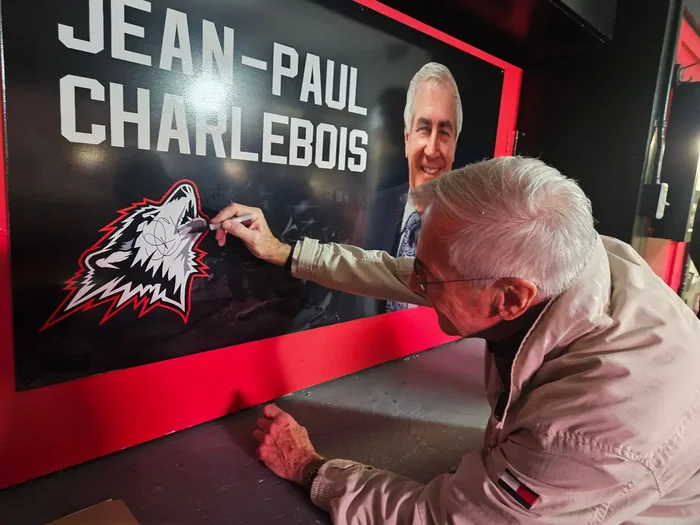 Jean-Paul Charlebois signant le mur en son hommage dans la loge de presse.